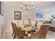 Elegant dining area with a glass-top table, seating for six, and decorative chandelier at 5000 Gasparilla Rd # 73A, Boca Grande, FL 33921