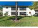 Condo with a grassy backyard, palm tree, and sliding glass doors at 502 Pine Hollow Cir # 502, Englewood, FL 34223