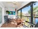 Spacious screened balcony overlooking a lake with outdoor furniture at 502 Pine Hollow Cir # 502, Englewood, FL 34223