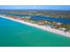 Stunning aerial view of a pristine beach close to a tranquil community with quick beach access at 5868 Denison Dr, Venice, FL 34293