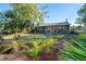 Serene backyard with tropical plants and a view of the screened porch at 5868 Denison Dr, Venice, FL 34293