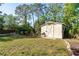 Exterior view of a backyard shed with grass and trees surrounding at 5868 Denison Dr, Venice, FL 34293