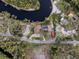 Aerial view of waterfront home with pool and private dock, nestled in lush Florida landscape at 651 Dixon Rd, Venice, FL 34292