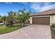 Brown double-car garage with paver driveway and landscaping at 6630 Willowshire Way, Bradenton, FL 34212