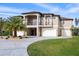 Stunning two-story home boasting a double-door entryway, balcony, and circular driveway with a palm tree feature at 710 Albee W Rd, Nokomis, FL 34275
