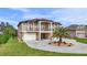 Stunning two-story home boasting a double-door entryway, balcony, and circular driveway with a palm tree feature at 710 Albee W Rd, Nokomis, FL 34275