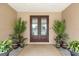 Inviting double door entrance with potted plants and a decorative outdoor rug at 710 Albee W Rd, Nokomis, FL 34275