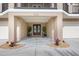 Inviting home entrance with double doors, potted plants, and access to a two-car garage at 710 Albee W Rd, Nokomis, FL 34275