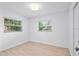 Bedroom with light wood flooring and dual windows at 7147 Lago St, Sarasota, FL 34241