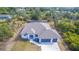 Aerial view of modern home featuring two-car garage, screened lanai and lush surroundings in a quiet neighborhood at 7330 Printer St, Port Charlotte, FL 33981