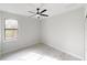 Bright bedroom with ceiling fan, a window overlooking greenery, neutral paint, and closet at 7330 Printer St, Port Charlotte, FL 33981