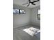 Bedroom with ceiling fan, gray wood-look floors, and large window at 7330 Printer St, Port Charlotte, FL 33981