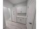 This hallway has shaker cabinets with dark hardware and light tile floors at 7330 Printer St, Port Charlotte, FL 33981