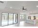 Bright, open-concept living space featuring wood floors, modern ceiling fan, and sliding glass doors to the pool at 7330 Printer St, Port Charlotte, FL 33981