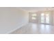 Bright living room featuring light wood floors, neutral walls, contemporary lighting fixtures, and glass paneled doors at 7330 Printer St, Port Charlotte, FL 33981
