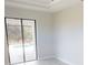 Neutral living room with white trim, light wood floors and sliding glass door leading to outdoor swimming pool at 7330 Printer St, Port Charlotte, FL 33981