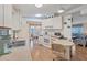 Bright kitchen with white cabinetry, breakfast bar, stainless steel sink, and wood laminate flooring at 735 Summersea Ct, Englewood, FL 34223