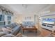 Comfortable living room featuring a large flat screen TV, hardwood floors, and stylish striped sofas at 735 Summersea Ct, Englewood, FL 34223
