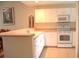 White kitchen with breakfast bar and appliances at 8100 Memory Ln # 207, Rotonda West, FL 33947