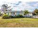 Charming light blue home with a well-manicured lawn and garden at 857 E 6Th St, Englewood, FL 34223