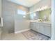 Spa-like bathroom with double vanity, walk-in shower, and neutral tile at 10958 Trevino St, Englewood, FL 34223
