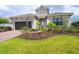 Two-story home with gray exterior, brick driveway and landscaping at 10958 Trevino St, Englewood, FL 34223