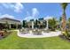 Community patio with tables, umbrellas, and lush landscaping at 10958 Trevino St, Englewood, FL 34223