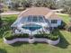Backyard featuring an enclosed pool and spa area with a patio, manicured lawn, and garden at 110 Barracuda Dr, Placida, FL 33946