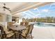 Covered outdoor patio featuring dining and lounge furniture alongside a pool and spa at 110 Barracuda Dr, Placida, FL 33946