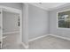 Bright bedroom featuring gray walls, white trim and a window view of green foliage at 119 White Pine Dr, Rotonda West, FL 33947