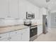 Well-equipped kitchen featuring stainless steel appliances, white cabinetry, and stylish tile backsplash at 119 White Pine Dr, Rotonda West, FL 33947