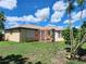 Spacious backyard with lush green grass, a patio area, and mature trees, perfect for outdoor entertaining at 13278 Carter Ave, Port Charlotte, FL 33981