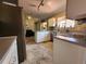 Bright kitchen with tile floors, white cabinets, stainless steel dishwasher, and neutral countertops at 13278 Carter Ave, Port Charlotte, FL 33981