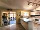 Bright kitchen featuring white cabinets and appliances, a breakfast bar, and an adjacent sunroom with natural light at 13278 Carter Ave, Port Charlotte, FL 33981