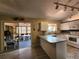Open kitchen featuring white cabinets, adjacent sunroom, and breakfast bar counter at 13278 Carter Ave, Port Charlotte, FL 33981