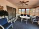 Bright sunroom with a ceiling fan, multiple windows with blinds, and comfortable seating arrangement at 13278 Carter Ave, Port Charlotte, FL 33981