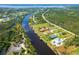 An aerial view of a waterfront property showcasing a house with a private dock and beautiful surrounding landscape at 13307 Eisenhower Dr, Port Charlotte, FL 33953