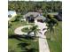 Aerial view of single-story home with circular driveway, landscaping, and waterfront access at 13307 Eisenhower Dr, Port Charlotte, FL 33953