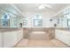 Elegant bathroom with double vanities and a large soaking tub at 13307 Eisenhower Dr, Port Charlotte, FL 33953