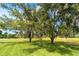 Lush front yard with mature trees, providing shade and beauty to the property's landscape at 13307 Eisenhower Dr, Port Charlotte, FL 33953