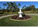 Landscaped area with a circular fountain and colorful flowers at 13307 Eisenhower Dr, Port Charlotte, FL 33953