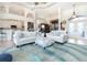 Spacious living room with light-colored sofas, patterned rug, and access to the kitchen at 13307 Eisenhower Dr, Port Charlotte, FL 33953