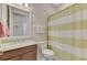 Clean bathroom featuring a vanity with stone counter, toilet, and shower with striped curtain at 13376 Creekside Ln, Port Charlotte, FL 33953