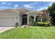 Inviting single-story home featuring a well-manicured lawn, lush landscaping, and a neutral-toned exterior at 13376 Creekside Ln, Port Charlotte, FL 33953