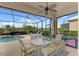 Outdoor patio with dining table, chairs, pool, and a view of lush greenery beyond the screen at 13376 Creekside Ln, Port Charlotte, FL 33953