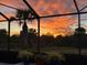 Stunning sunset view from the screened-in patio, overlooking the backyard and trees at 13376 Creekside Ln, Port Charlotte, FL 33953