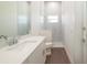 Bright bathroom featuring white marble tiling, modern fixtures, glass shower and wood-look flooring at 159 Colony Point Dr, Punta Gorda, FL 33950