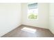A simple, minimalist bedroom with a window, hardwood floors, and neutral walls at 159 Colony Point Dr, Punta Gorda, FL 33950