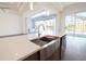 Kitchen island with stainless steel sink, modern faucet, quartz countertop, and view to screened lanai at 159 Colony Point Dr, Punta Gorda, FL 33950