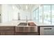 Modern kitchen island featuring stainless steel sink, quartz countertop, and view of the lanai with pool at 159 Colony Point Dr, Punta Gorda, FL 33950